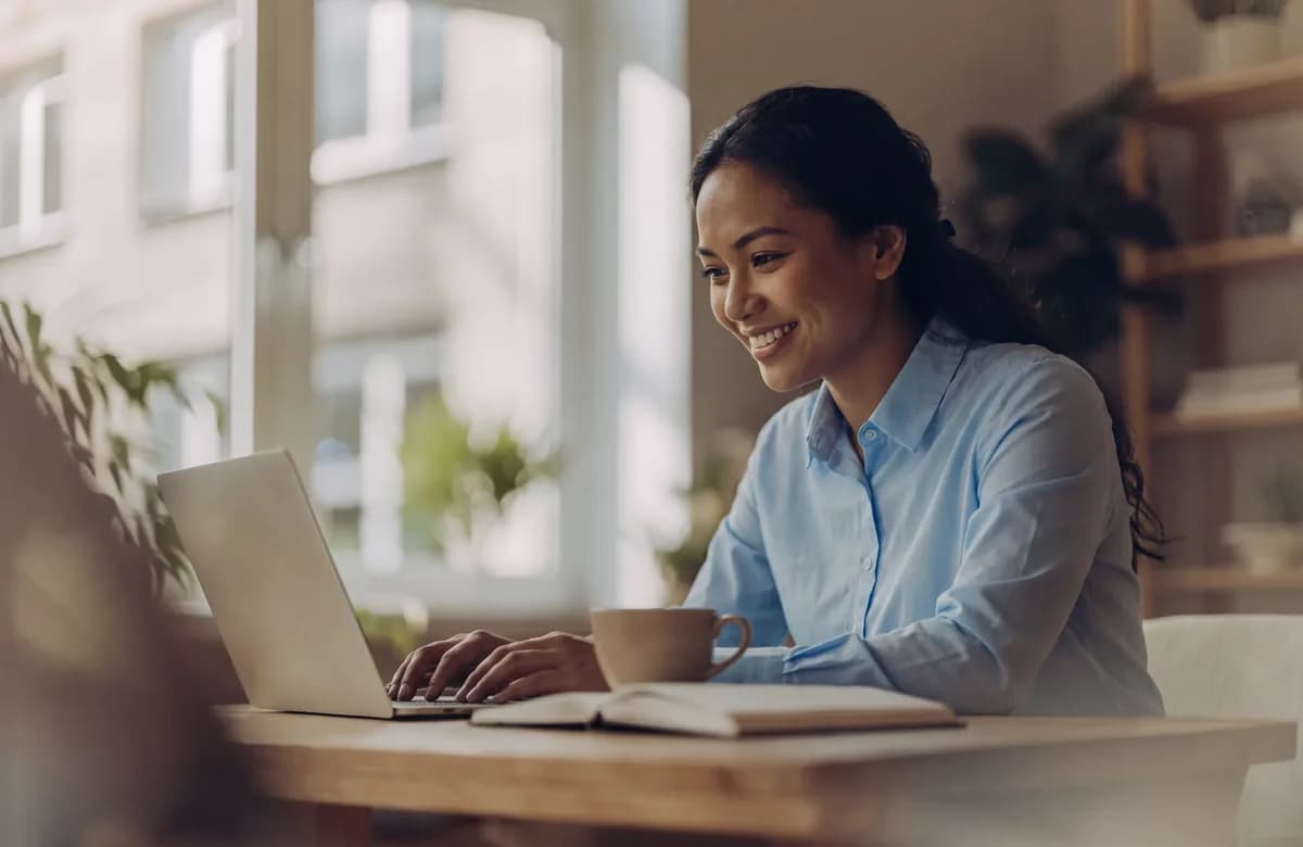 A woman working on her profile on a laptop